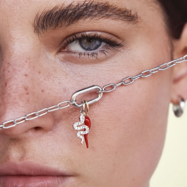 woman with charm necklace in front of face